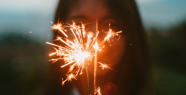 a woman holding a sparkler. Image by Brynden, courtesy of Unsplash