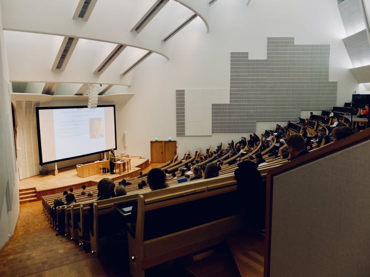 a college lecture hall filled with students. Photo by Dom For, courtesy of Unsplashed
