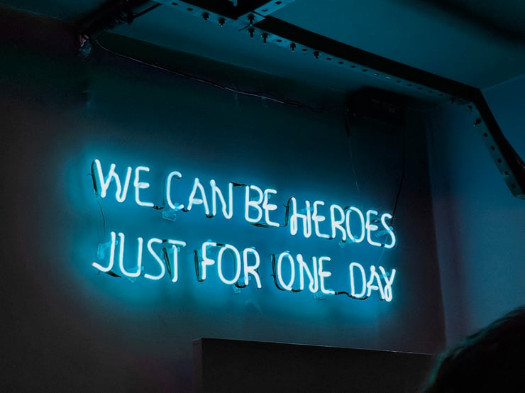 Neon side that reads, "We can be heroes just for one day."